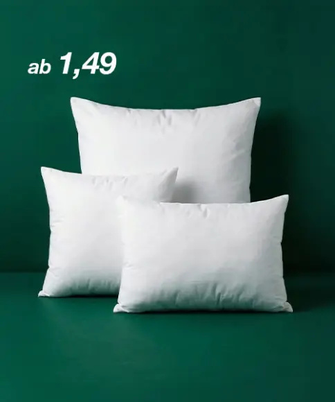 Drei weiße Kissen in unterschiedlichen Größen sind vor einem dunkelgrünen Hintergrund angeordnet. Links steht der Preis „ab 1,49“.